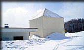 the station building buried under deep snow and the 3.8-m antenna covered with tent-type protection